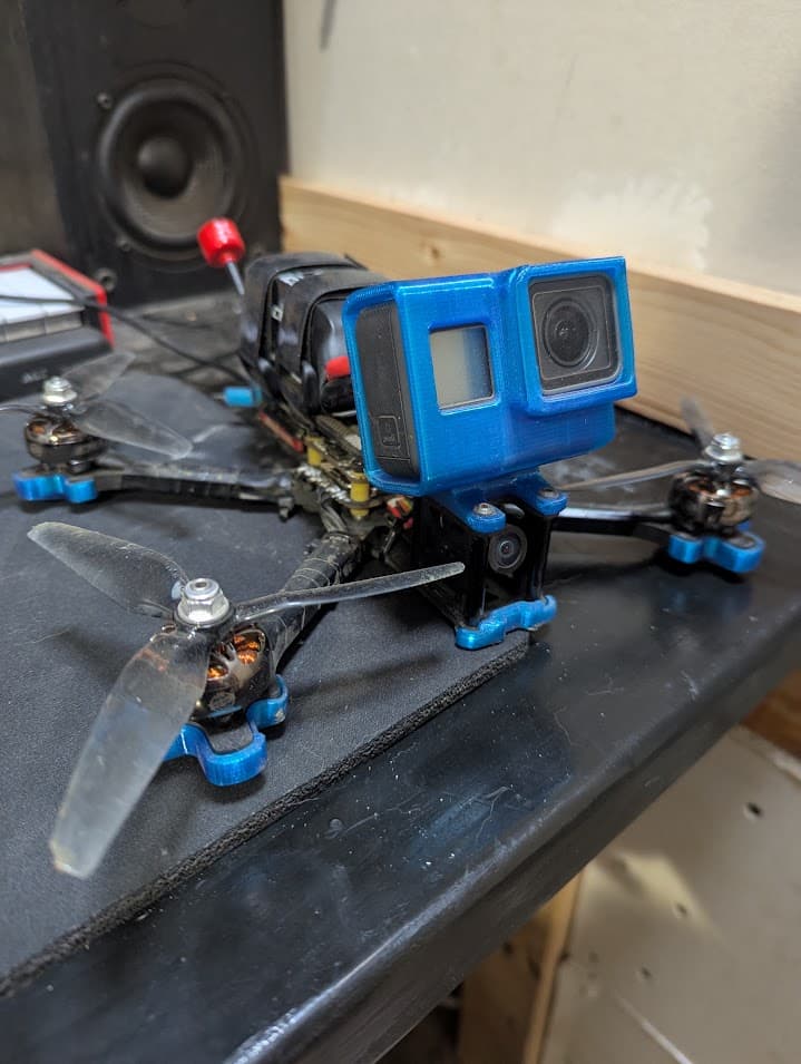 Close front view of the Source One V5 with the early blue printed GoPro mount above the analog FPV camera