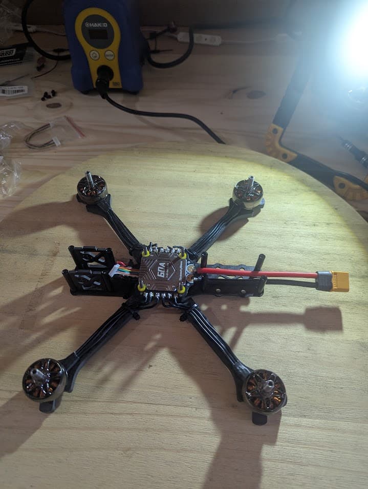 Progress photograph of the Source One V5 after the motor wires were routed and soldered around the outside of the ESC pads